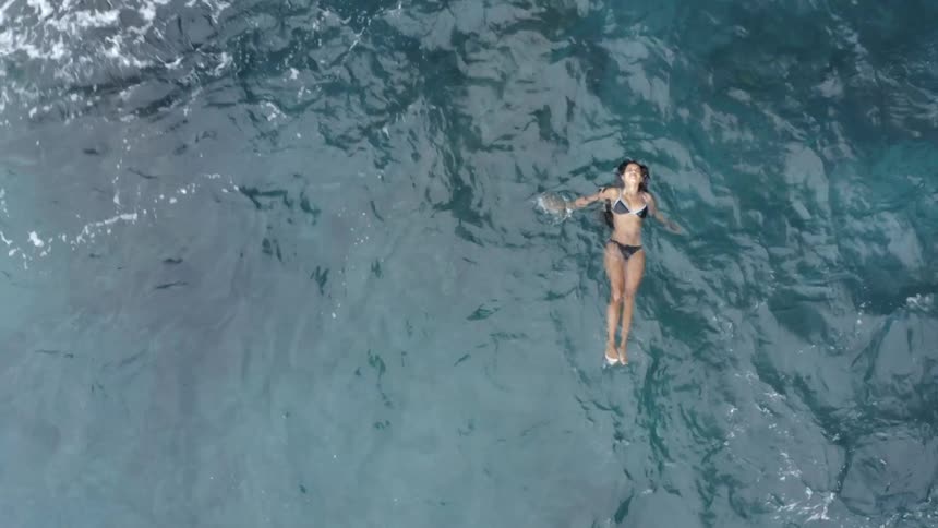 A woman is swimming in the ocean water