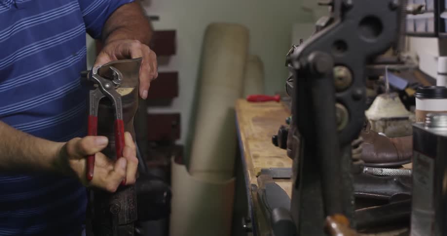 A man is repairing a boot in a shop
