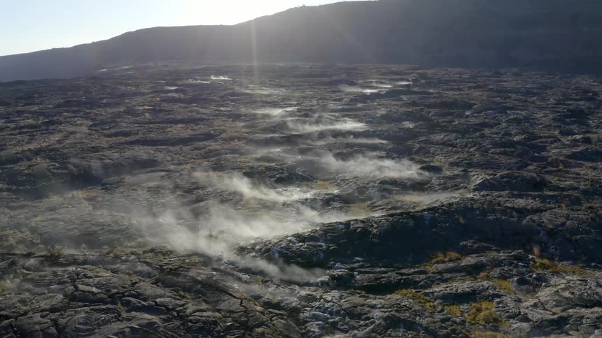 Steam rises from the fields by the mountains
