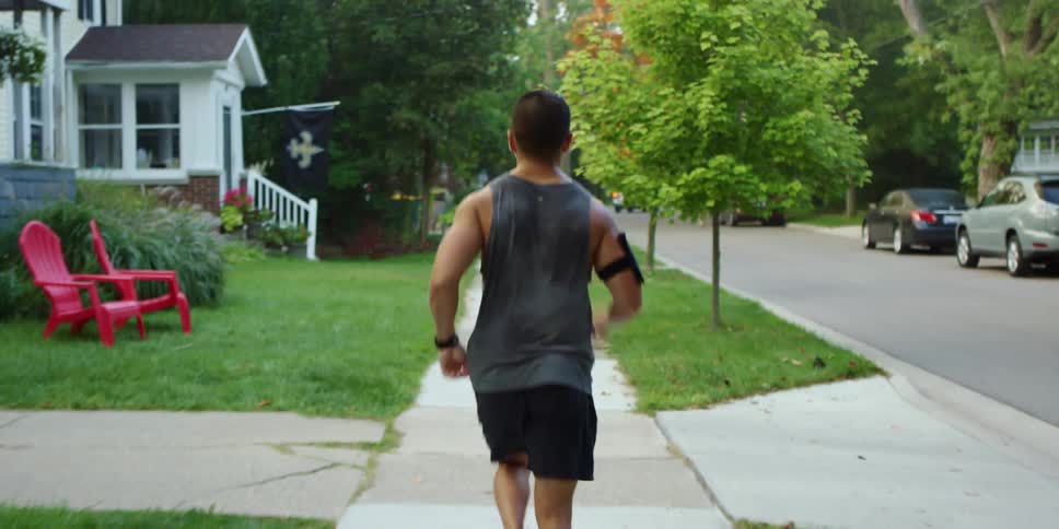 A man is jogging on the sidewalk