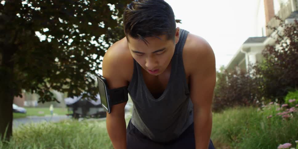 Asian young man sweating after jogging on the streets of a neighborhood