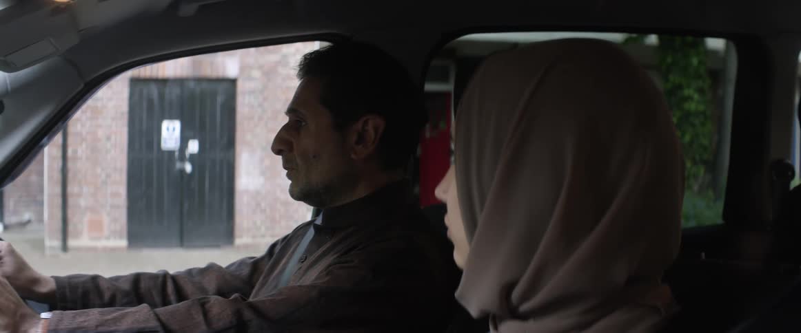 A man and woman are sitting in a car