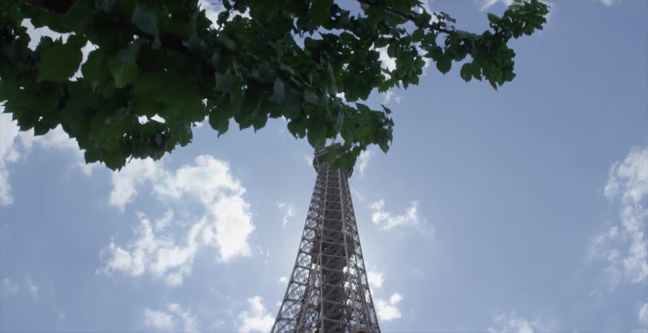 A large tower sits in a partially cloudy sky