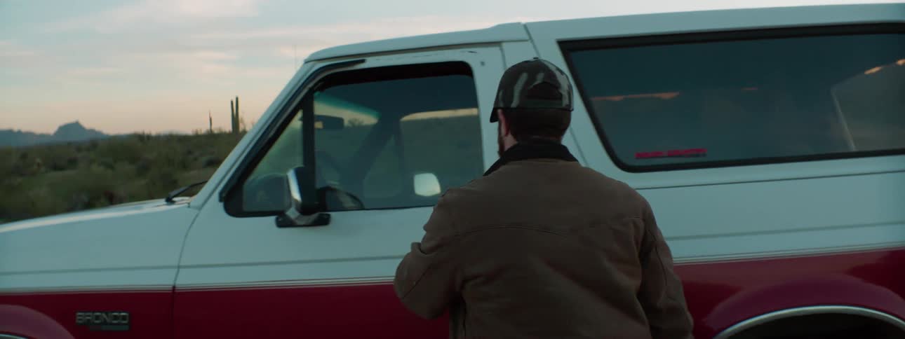 Man walks towards a truck and opens the truck door