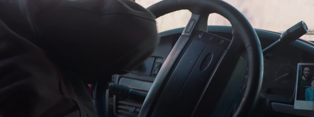 A man is getting out of a vehicle and walking outdoors