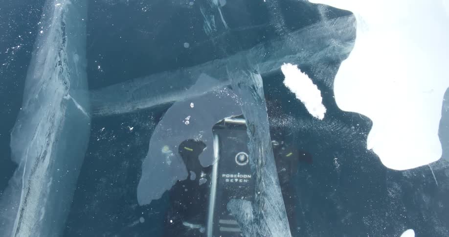 A diver moves forward under the frozen surface