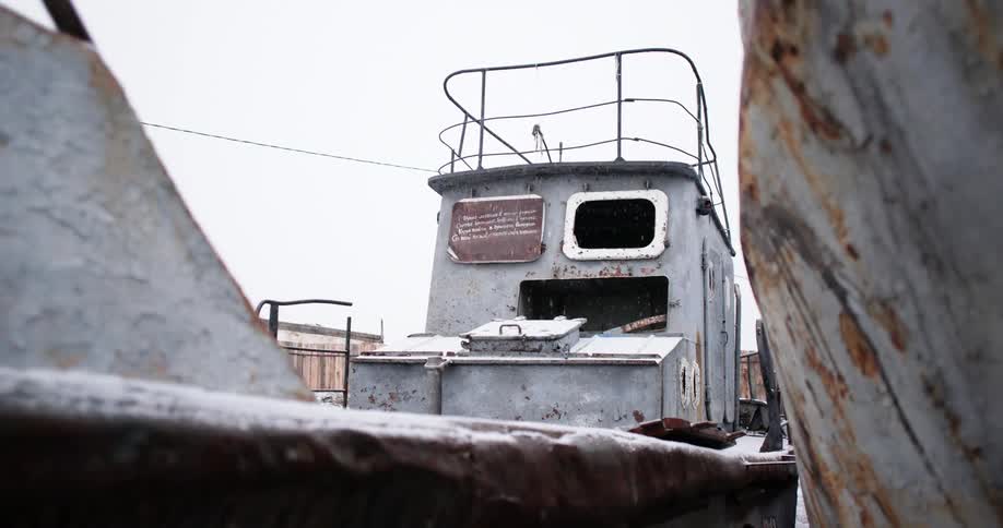 Rusted hull of fishing boats under the falling snow