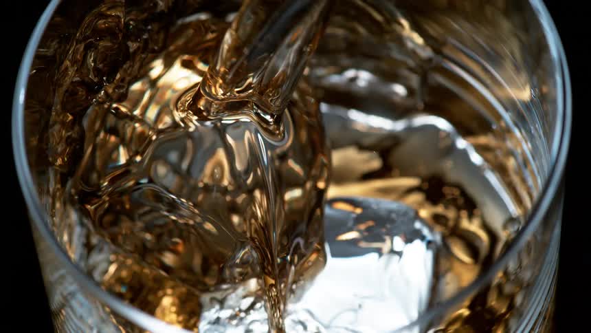 Alcohol is poured over a cube of ice