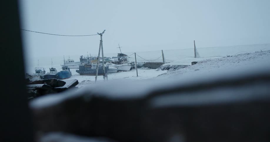 The boats are covered with snow at the docks
