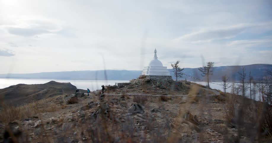 Two people walking down a hill with a architecture on top
