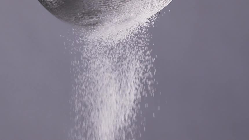 Flour is sifted through a mesh colander
