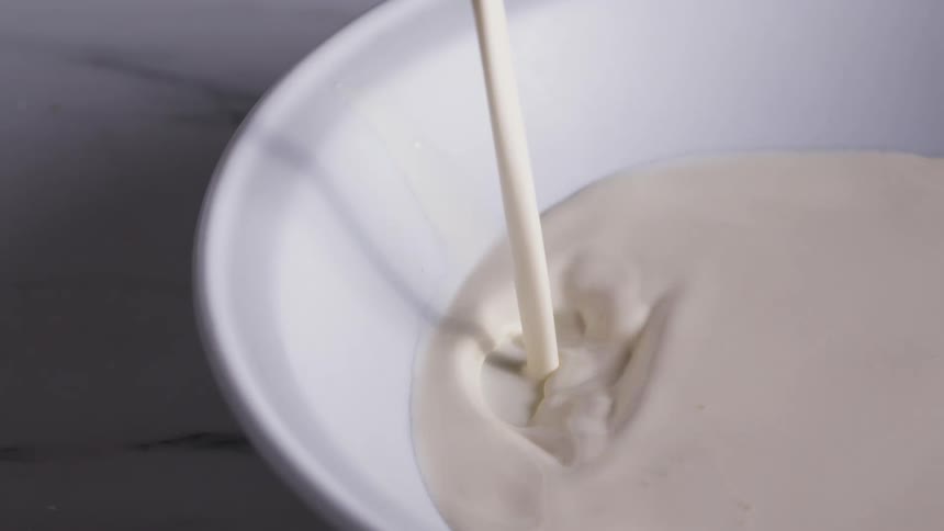 Milk being poured in to a bowl