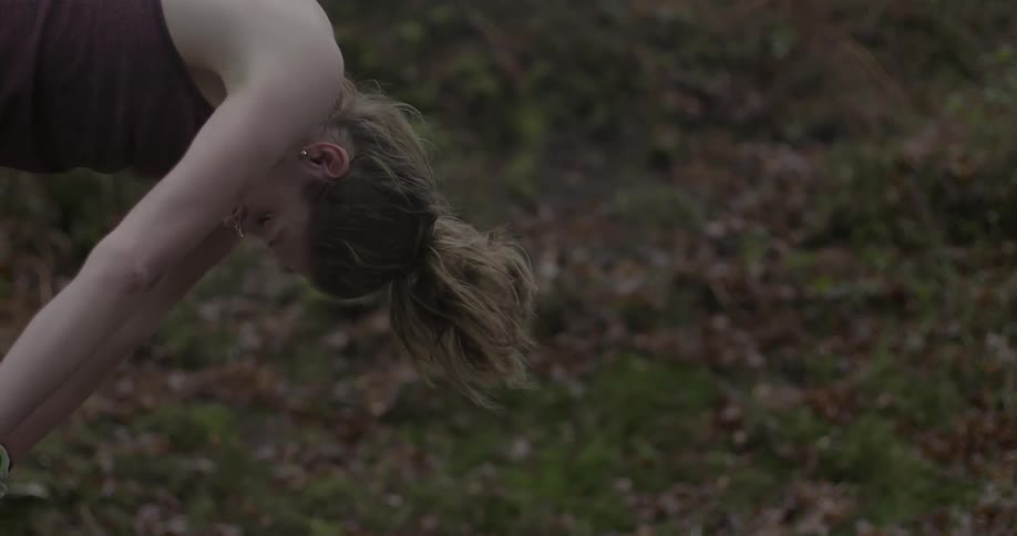 Woman bending over and resting while exercising outdoors alone