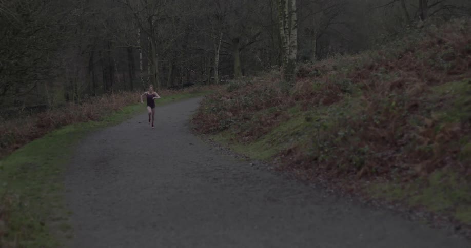 A woman is running downhill on a path