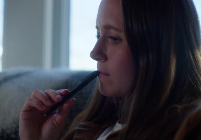 A woman takes some notes sitting on the couch