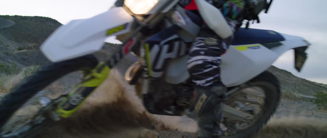 A person makes a sharp turn on a dirt bike