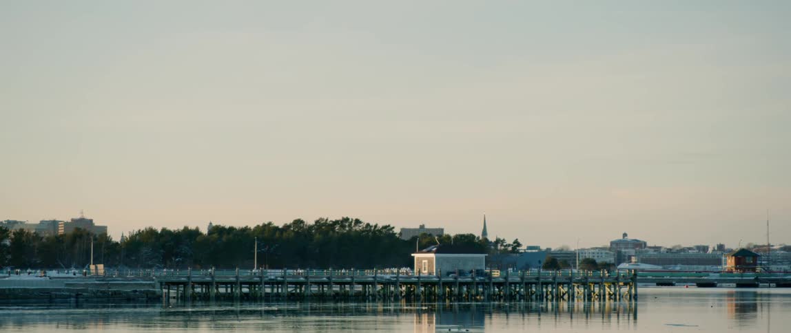 The sun sets on a pier along the coast of Portland Maine