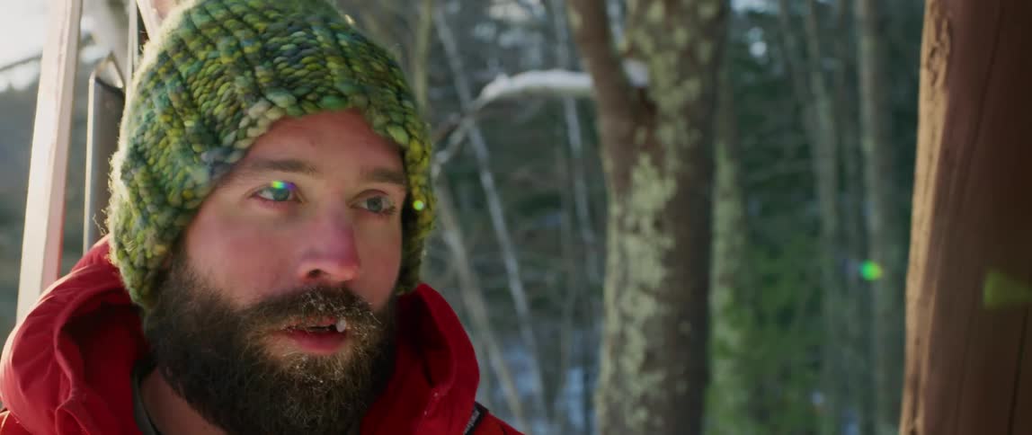 An outdoorsman setting out on a winter hike pauses and looks off in the distance