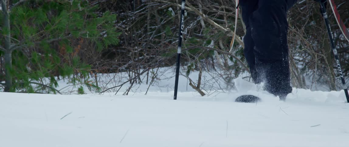 A man struggles through deep snow in the wilderness