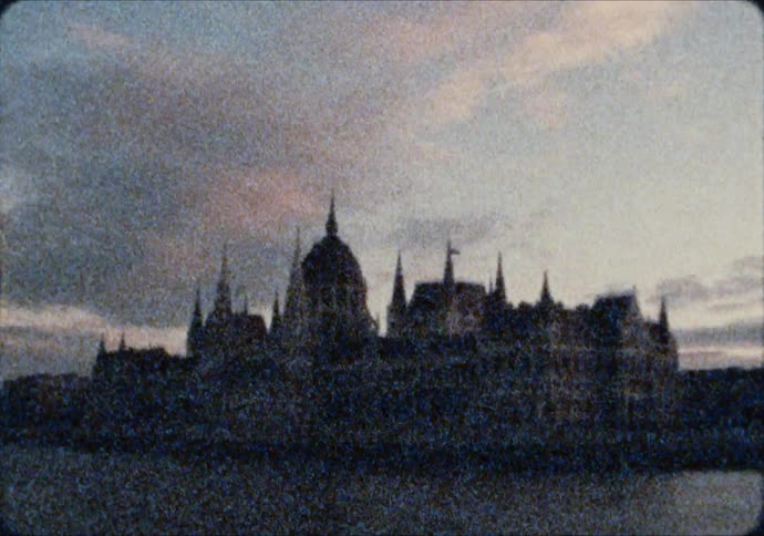 The Hungarian Parliament Building is silhouetted against the dawn sky