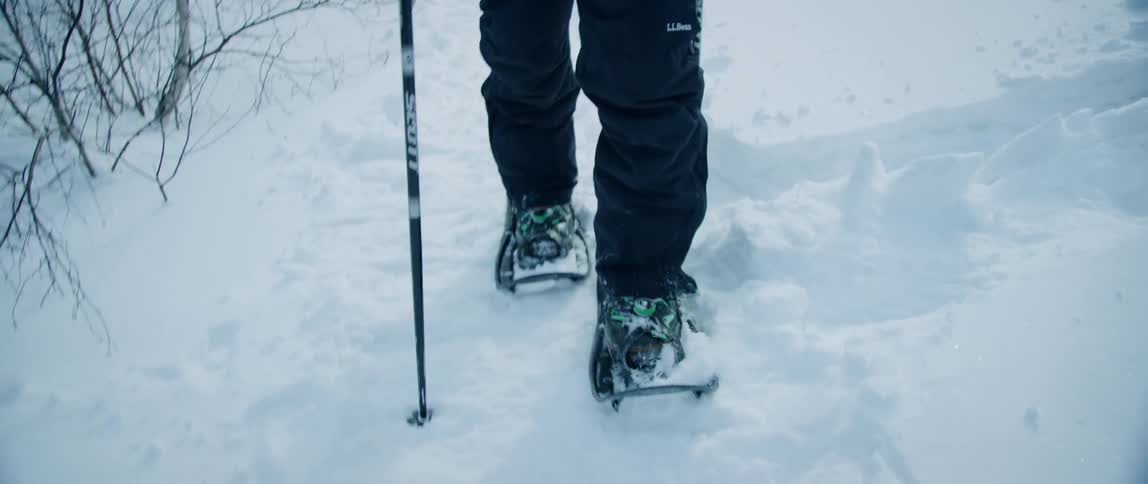 An outdoorsman struggles to hike in the frozen wilderness