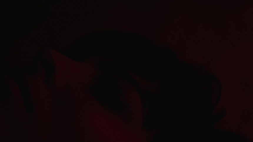 A red light shines on a womans face