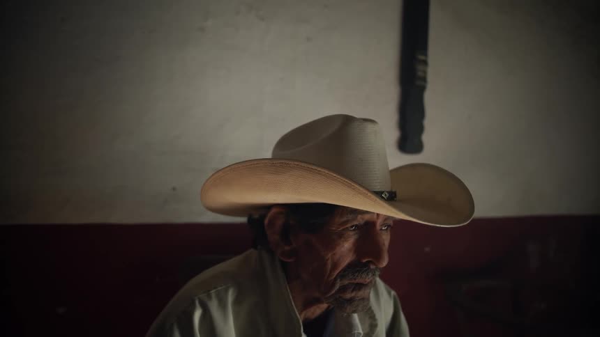 A elderly man sits inside a building