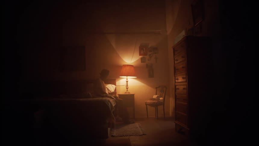 A man walks over to his bed to sit