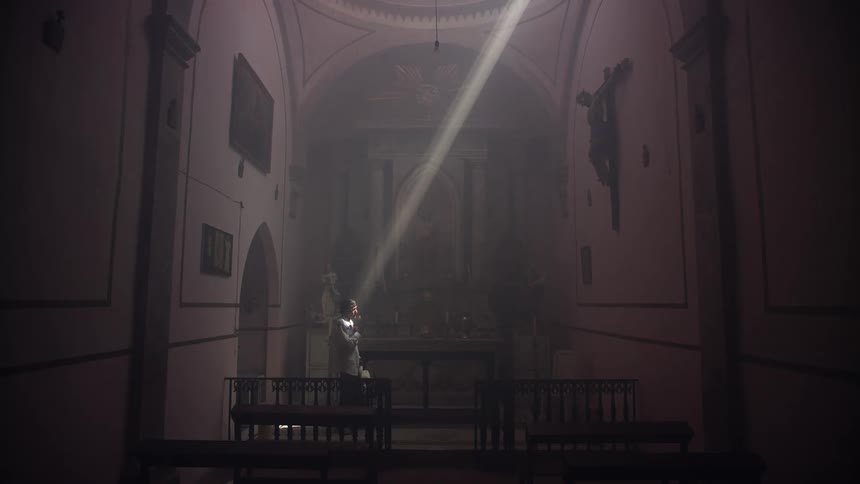 A man removes his hat in the church