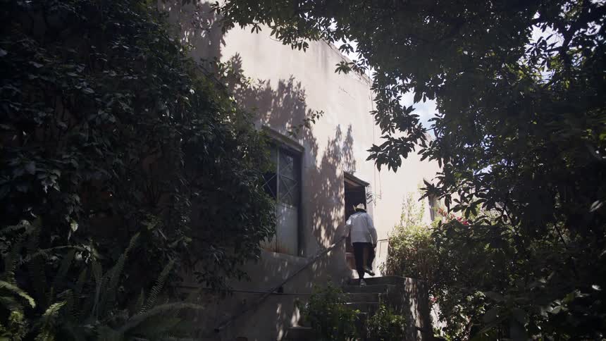 A man walks up stairs outside a building