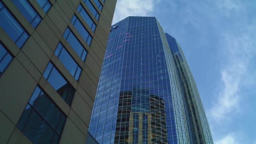 Clouds float above a skyscraper in a city