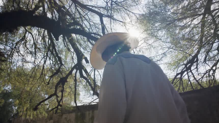A man is hiking outdoors while wearing a sunhat