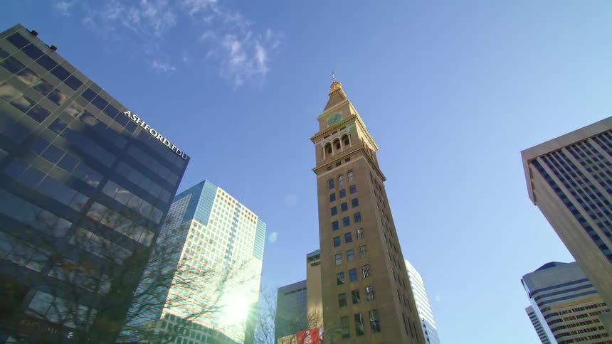 A narrow yellow skyscraper in a metropolis during the day