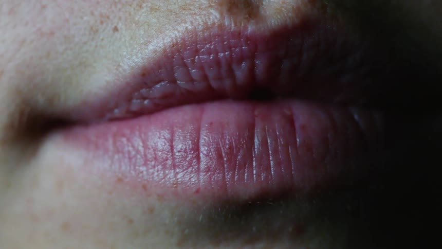 A womans lips turn up slightly as she smiles