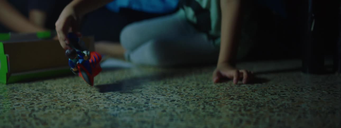 A mother and son play with toys on the floor