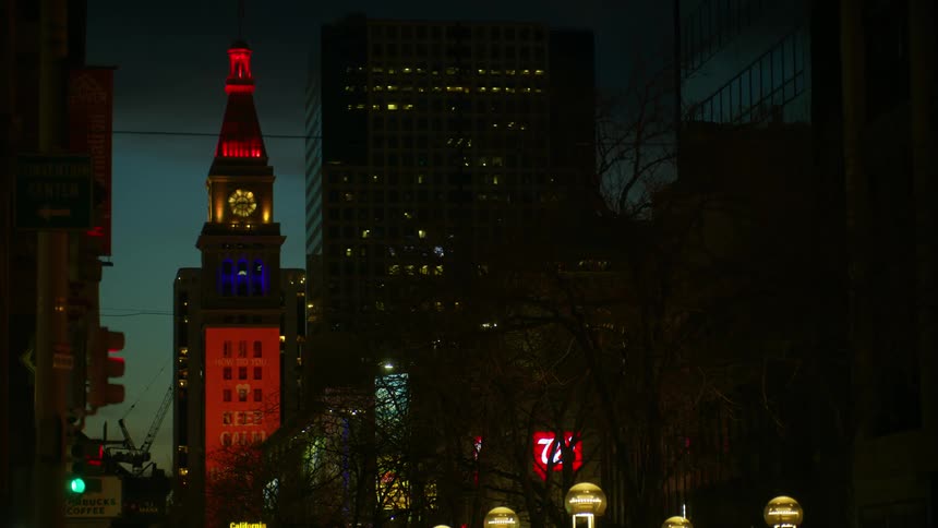 An advertisement being projected on the side of a skyscraper in a metropolis at night