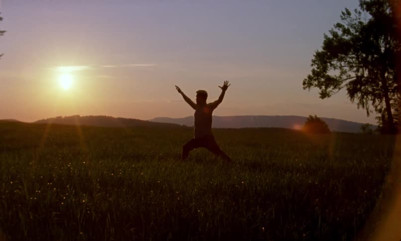 A man is exercising outdoors at dusk