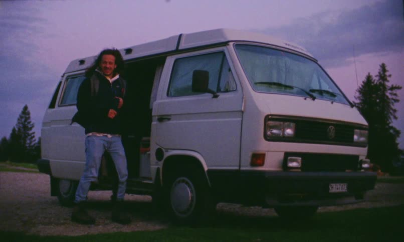 A young man jumps out of a van and puts a headband on