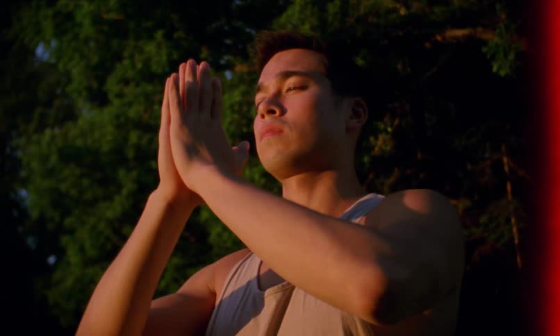 A young man does yoga outside
