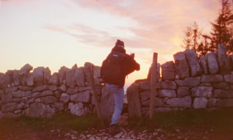 A man is hiking outdoors during sunset