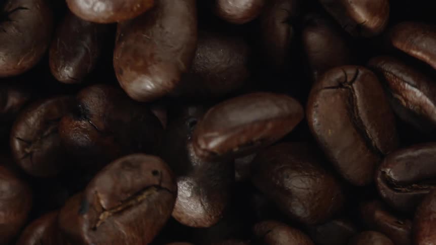 Whole coffee beans spin and stir in a machine