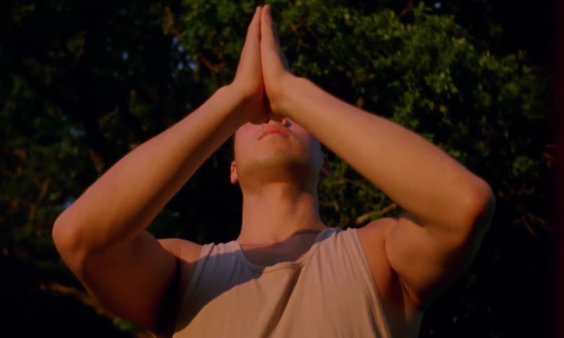 A man is stretching by the tree