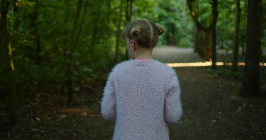 A young girl walking through a forest