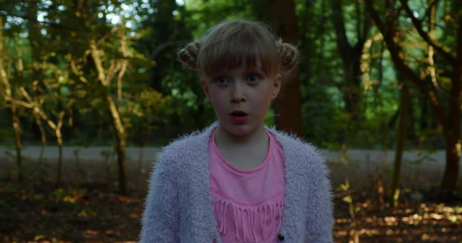 A young girl walking through a forest