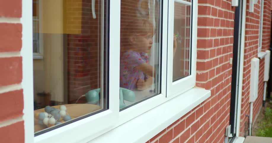 A girl is drawing on the window inside
