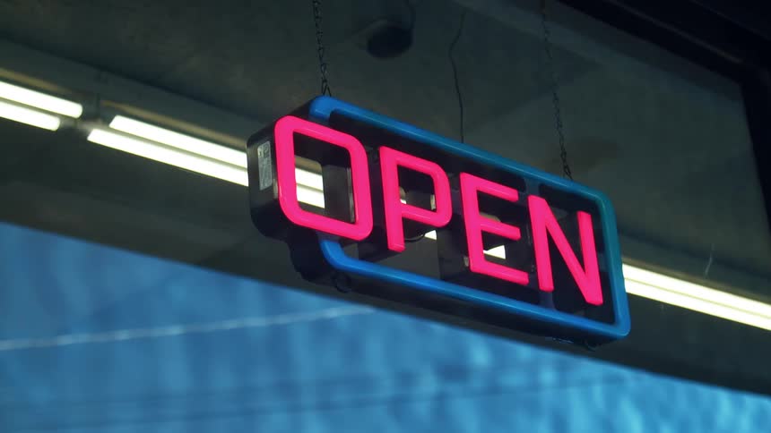 An open sign hangs in a business window