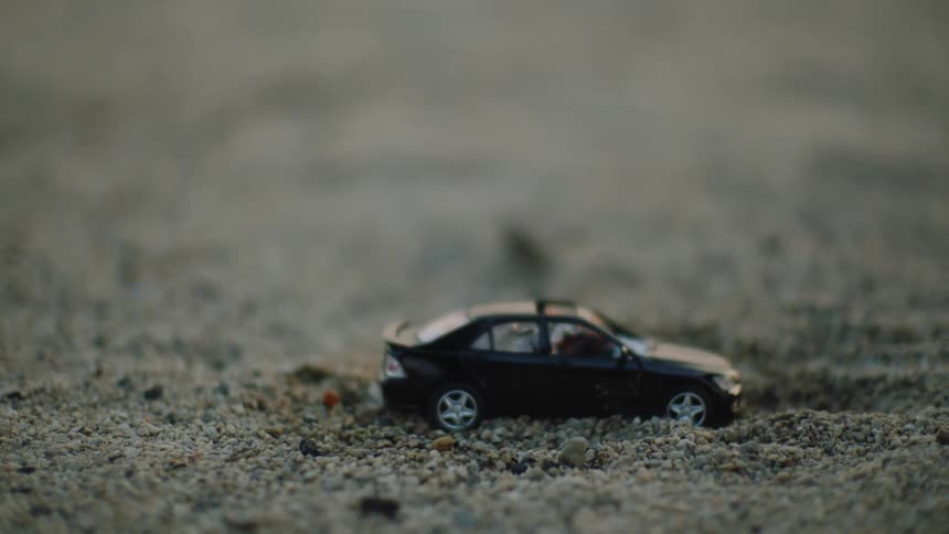 A toy car is set on fire outdoors