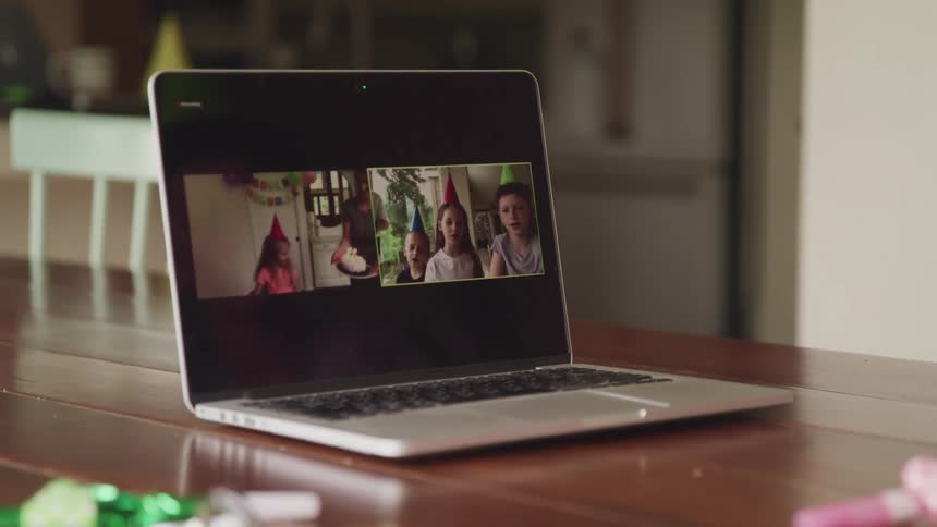 A video conference of a birthday party is on the laptop