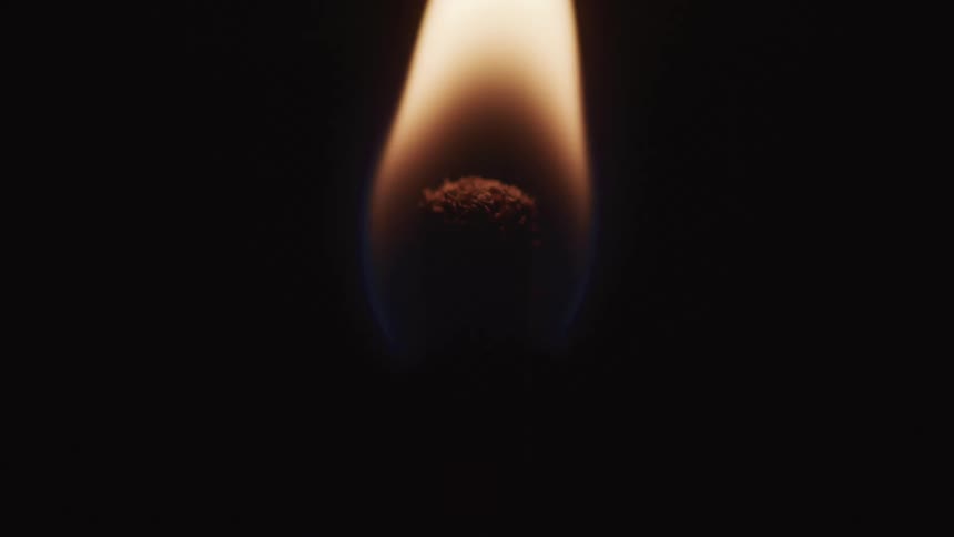 Match burns against black background