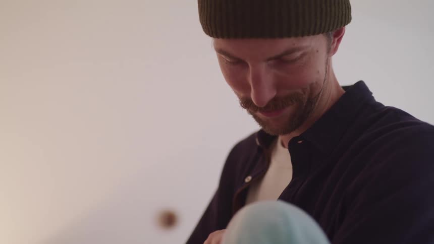 Man holds an infant and smiles